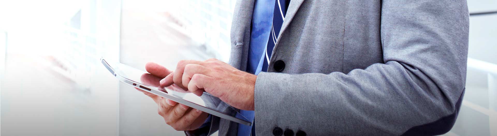 business man in a gray suit on a tablet closeup