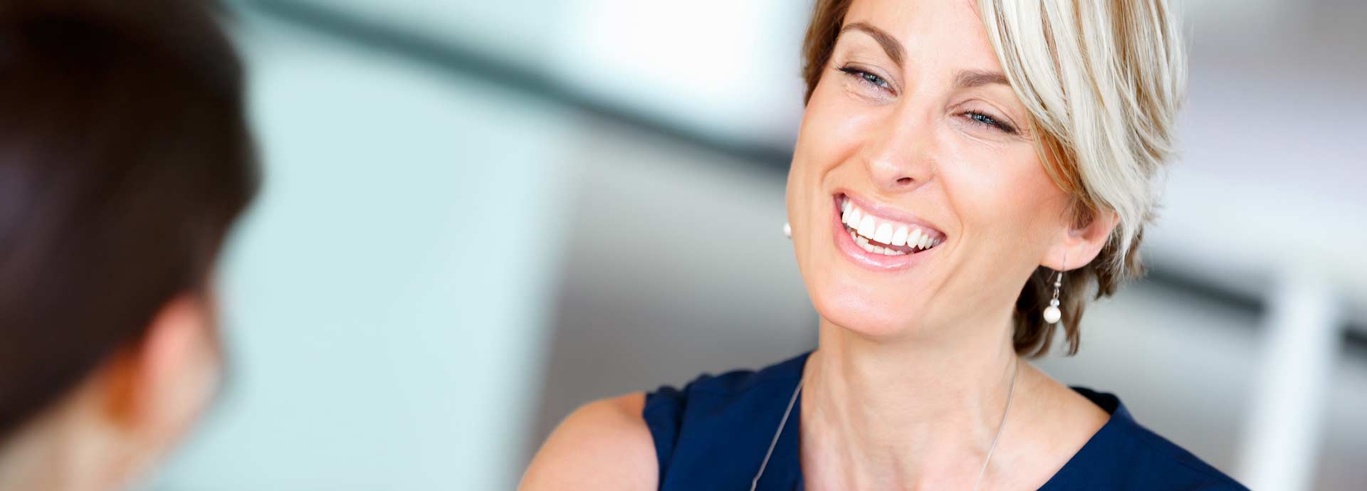 business woman in blue smiling looking at a client